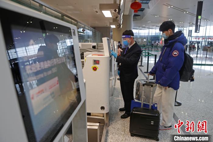 东航工作人员协助旅客办理自助托运行李。　殷立勤 摄